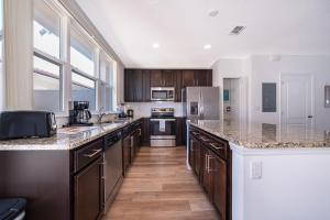 a kitchen with wooden cabinets and granite counter tops at Home with amenities - Family vacation in Orlando in Kissimmee