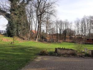 a field of grass with trees and a brick walkway at Ferienwohnung auf dem Land in Ladbergen
