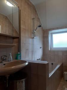 a bathroom with a sink and a tub and a shower at Ferienwohnung auf dem Land in Ladbergen