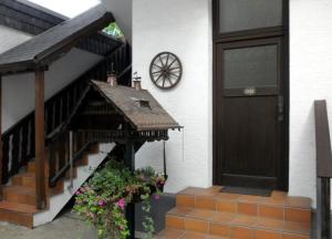 a house with a door and a staircase with flowers at Gästehaus Vis-A-Vis in Rüdesheim am Rhein