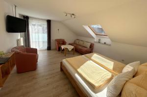 sala de estar con cama, sofá y TV en Gästehaus Sommertal, en Meersburg