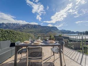 een tafel en stoelen op een patio met uitzicht op de bergen bij Le Rose Sul Lago in Pescate