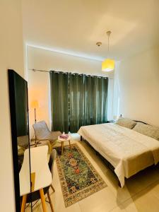 a bedroom with a bed and a couch and a chair at Modern Room With Attached Bathroom Near Rigga Metro & Close to Airport in Dubai