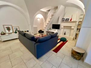 un soggiorno con divano blu e TV di Superga 15 - Home Design a Cisternino