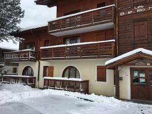 a building with snow on the ground in front of it at Charmant appartement « Les belles roches » Piscine in Notre-Dame-de-Bellecombe +4 photos