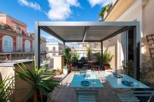 a patio with blue tables and chairs on a balcony at Residenza Cavallini in Rome