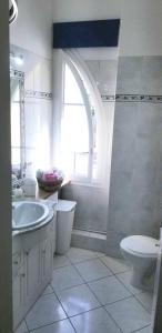 La salle de bains blanche est pourvue d'un lavabo et de toilettes. dans l'établissement Happydays Cannes spacieux duplex 70m2, à Cannes