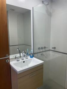 a bathroom with a sink and a shower with a mirror at Dpto Arroyito in Rosario +21 photos