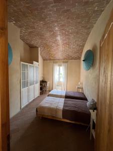 una camera con letto e soffitto in mattoni di MAISON DE CARACTERE A PIGNA a Pigna