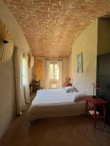 una camera da letto con un grande letto e un soffitto in mattoni di MAISON DE CARACTERE A PIGNA a Pigna