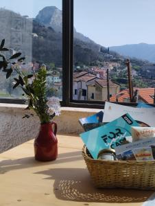 een mand met boeken op een tafel met een vaas bij SBILENCA & SBILENCHINA - TOP per MTB - Climbers e Famiglie - giardino - BBQ - nel Finalese in Calice Ligure