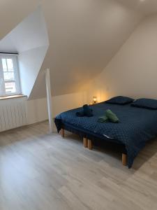 Schlafzimmer mit einem Bett mit blauer Decke in der Unterkunft Beau duplex hyper centre in Coutances