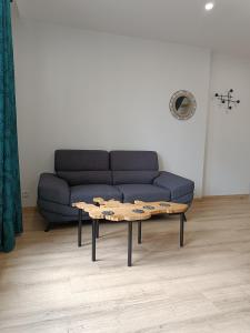 ein Wohnzimmer mit einem Sofa und einem Couchtisch in der Unterkunft Beau duplex hyper centre in Coutances