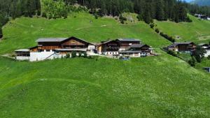 an aerial view of a house on a green hill at Wachtlerhof in Matrei in Osttirol