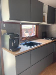 a kitchen with a sink and a counter with a window at Welcome, relax and enjoy your stay in Putten