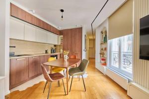 パリにあるElegant central flat in Paris, near Saint Germainの木製のテーブルと椅子のあるキッチン