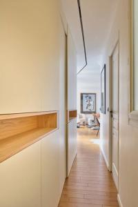 パリにあるElegant central flat in Paris, near Saint Germainの白いキャビネットと木製の床が備わる家の廊下