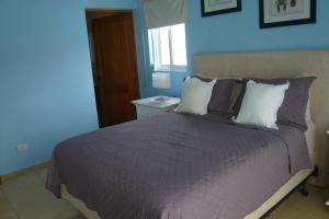a bedroom with a bed with purple sheets and a window at The blue lagoon of the Caribbean Sea. Velero 205.Cadaques Caribe in La Fragata