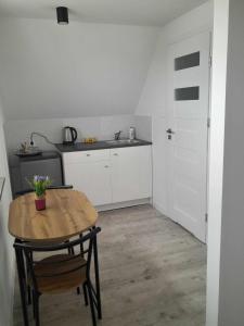 una piccola cucina con tavolo in legno e lavandino di Apartamenty Przy Zamku - Noclegi Pasłęk a Pasłęk