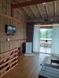 蜂蜜島的住宿－Pousada Do Chicão，一间带电视和大窗户的客厅