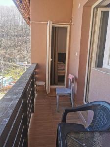 balcone con tavolo, sedie e finestra di Apartman Aleksandar 2 a Ribarska Banja