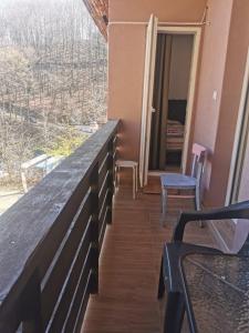 einen Balkon mit einem Tisch und Stühlen sowie Aussicht in der Unterkunft Apartman Aleksandar 2 in Ribarska Banja