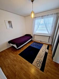 a small room with a bed and a window at Stort hus uthyres med utegård gräsmatta in Borås