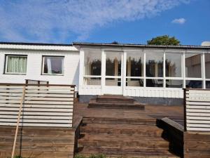 布羅斯的住宿－Stort hus uthyres med utegård gräsmatta，前面设有木制甲板的房子