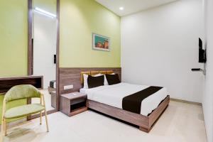 a bedroom with a bed and a chair at Super Collection O Kalyan West in Mumbai