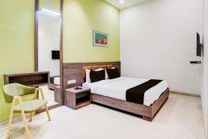 a bedroom with a bed and a chair in it at Super Collection O Kalyan West in Mumbai
