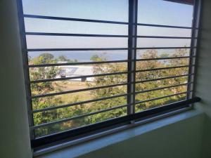 a window with a view of a field of trees at SwanLakeview3br, Wi-Fi, Netflix, Balcony, Sunset. in Kisumu