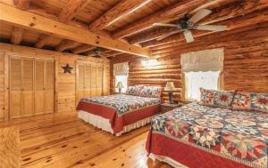 BuffaloにあるDragonfly Meadows Log Cabinのログキャビンベッドルーム(ベッド2台、シーリングファン付)