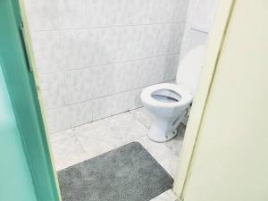 a bathroom with a white toilet in a stall at SwanLakeview3br, Wi-Fi, Netflix, Balcony, Sunset. in Kisumu