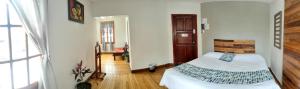 una camera da letto con un letto e un corridoio di Minka Hostel a Quito