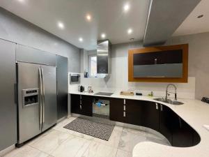 a kitchen with a refrigerator and a sink at Appartement Standing piscine intérieur privatisée . in Mutzig