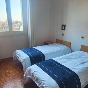 2 Betten in einem Zimmer mit Fenster in der Unterkunft Hotel oro in Cento