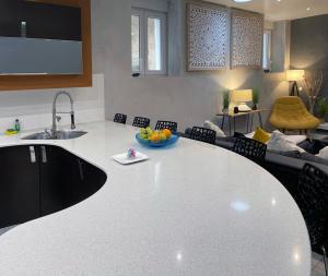 a kitchen and living room with a large white counter top at Appartement Standing piscine intérieur privatisée . in Mutzig +9 photos
