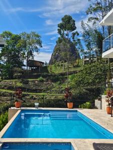 a swimming pool with a hill in the background at Hermosa habitación 203 deluxe GC in Guatapé