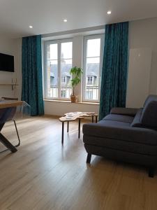 ein Wohnzimmer mit einem Sofa und einem Tisch in der Unterkunft Beau duplex hyper centre in Coutances