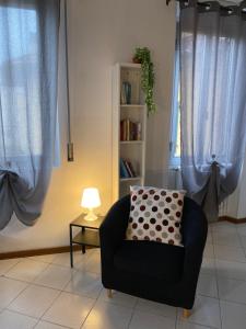 a living room with a chair and a book shelf at Civico 8 in Prato