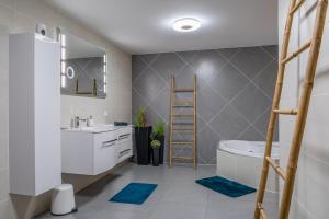 a bathroom with a ladder and a sink and a tub at Appartement Standing piscine intérieur privatisée . in Mutzig