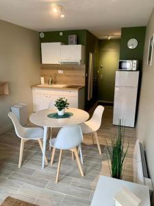 a small kitchen with a table and chairs in a room at Côte et mer (Blériot-plage) in Sangatte