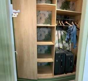 a wooden closet with suitcases in it at Côte et mer (Blériot-plage) in Sangatte