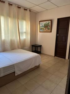 um quarto com uma cama, uma janela e uma porta em Hotel Almirante Padilla em Ríohacha