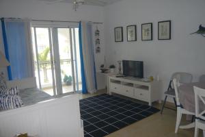 a living room with a tv and a couch and a table at Cadaques Caribe Boulevard Dominicus Americanus Carretera a Bayahibe Vel 206 in Bayahibe
