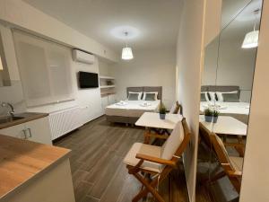 a room with two beds and a table and a kitchen at Cute studio near acropolis in Athens