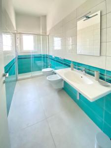 a blue and white bathroom with two sinks and a toilet at Seaway Accommodation " Private Parking " in Tropea +137 photos