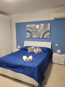 a blue bed with two white towels on it at Kristal in Cinisi