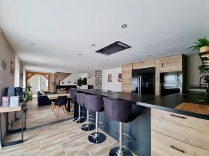 a kitchen with a bar with purple bar stools at les piafs du der 1 in Joncreuil
