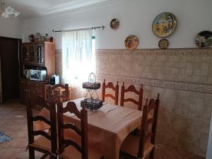 a dining room with a table and chairs and a kitchen at Casa dos avós in São Brás de Alportel